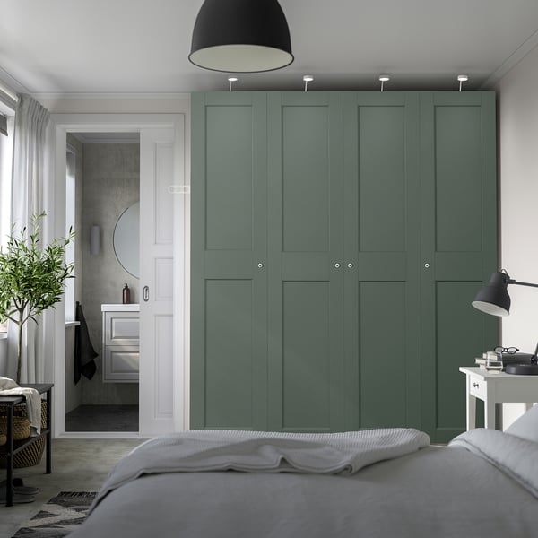 Moderne slaapkamer met hoge groene PAX kledingkast en strakke vakken.
