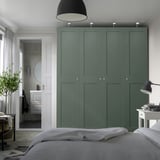Moderne slaapkamer met hoge groene PAX kledingkast en strakke vakken.