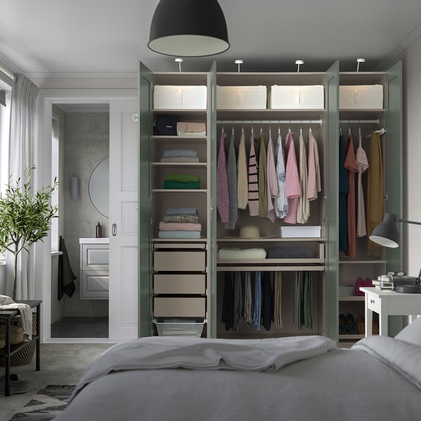 Moderne slaapkamer met PAX kledingkast, kleding, planken, verlichting, bed en plant.