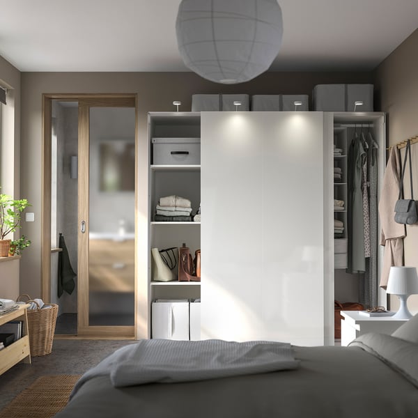 Moderne slaapkamer met IKEA PAX kledingkast. Schuifdeuren, verlichting, georganiseerde opslag. Grijs en wit minimalistisch ontwerp.