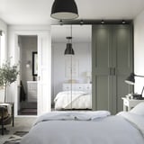Moderne minimalistische slaapkamer met PAX kledingkast, groen en wit, spiegeldeuren en bed.