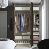 Moderne kast met kleding en planken, voorzien van langzaam sluitende deuren.