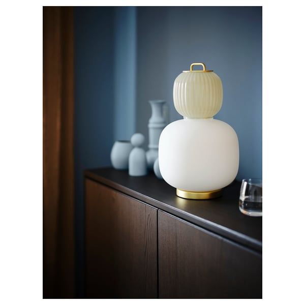 Unieke lamp met geel en wit glas, gouden voet, lijkend op traditionele lantaarns. Perfect voor decoratieve verlichting.