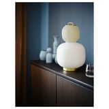 Unieke lamp met geel en wit glas, gouden voet, lijkend op traditionele lantaarns. Perfect voor decoratieve verlichting.