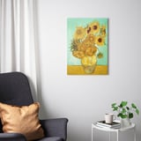 Mooie woonkamer met PJÄTTERYD canvas print van van goghs zonnebloemen, grijze bank, witte bijzettafel en groene plant.