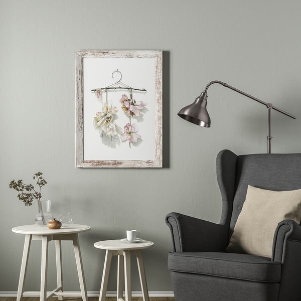 Woonkamer met grijs PLOMMONTRÄD frame, bloemen en stijlvolle lamp.
