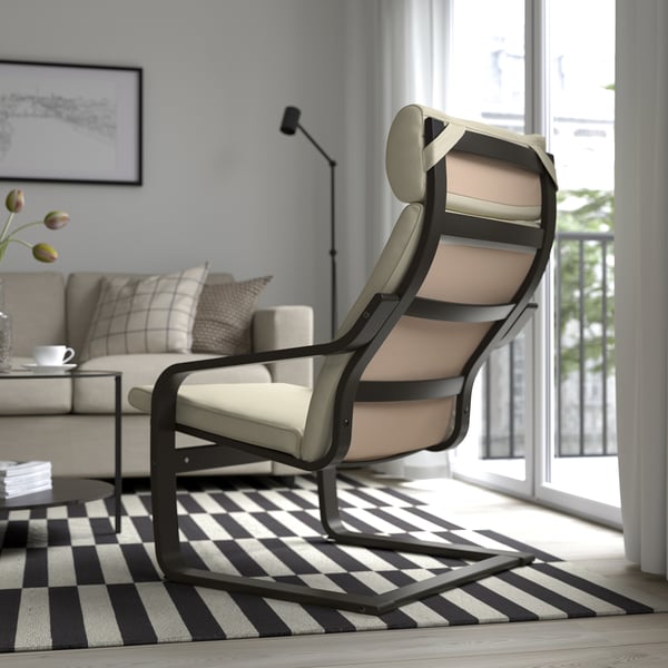 Moderne woonkamer met beige POÄNG stoel, gestreept vloerkleed en zonnig raam.