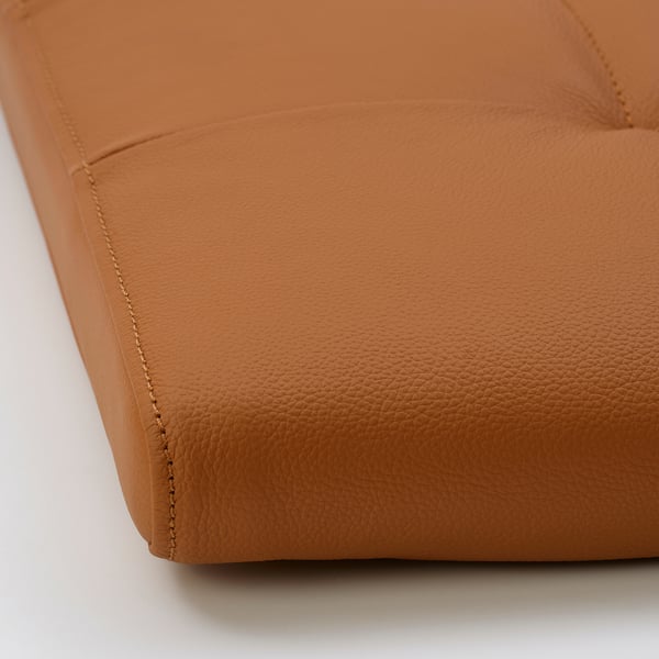 Close-up van hoogwaardige, beige leren kussens met nette stiksels, die zachte textuur en detail accentueren.
