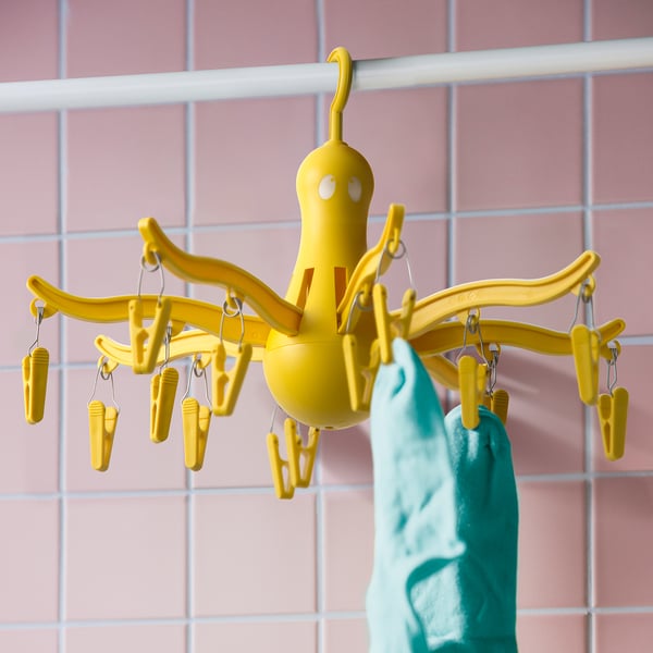 Gele octopusvormige wasdroger met 16 haringen die blauw item ophangen, wat het gebruik ervan voor het drogen van kleine wasartikelen aantoont.