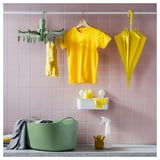 Kostbare groene droger met 16 haringen, gele kleding, paraplu op roze tegels.