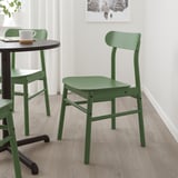 Groene RÖNNINGE stoelen met houtnerf rond kleine zwarte tafel, mid-century design, berkenfineer, stevig en compact.