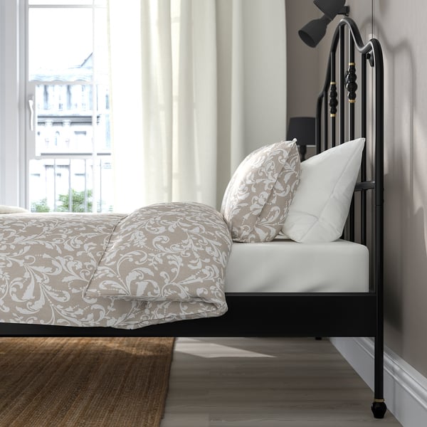 Sierlijk bed met uitzicht op de stad door groot raam.