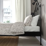 Sierlijk bed met uitzicht op de stad door groot raam.