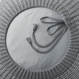 Grijze gehaakte poef met kwastjes, die ook dienst doet als voetenbankje of extra zitplaats, afgebeeld in cirkelvorm.