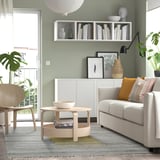 Gezellige woonkamer met grijs SJÖTÅTEL vloerkleed, bank, planten en foto's.