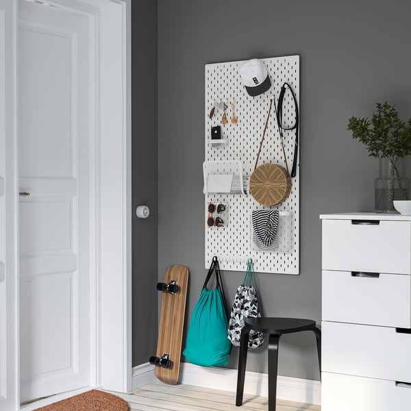SKÅDIS ophangbord organizer met accessoires op grijze muur.