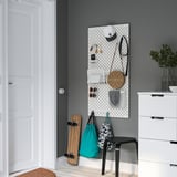 SKÅDIS ophangbord organizer met accessoires op grijze muur.