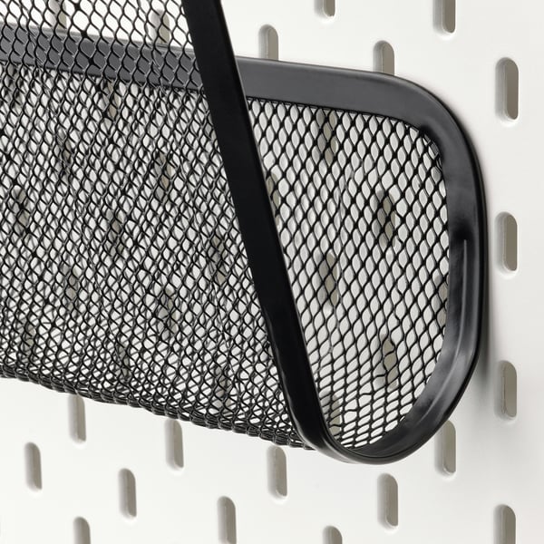 Zwarte metalen opbergmand van gaas op een ophangbordsysteem, stevig bevestigd met zwarte haken, ontworpen om items efficiënt te organiseren.