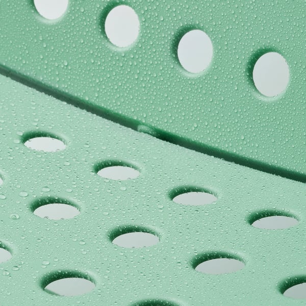 Geperforeerde groene tuinstoel met waterdruppels, ontworpen voor comfort en eenvoudige reiniging.