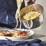 Spaghetti in een bord gieten met het afneembare handvat van de SLÄTROCKA-potten.