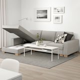 Moderne woonkamer met l-vormige SÖRVALLEN-bank, voorzien van chaise longue en opbergruimte. Versierd met kussens, vaas en salontafel op een kleed.