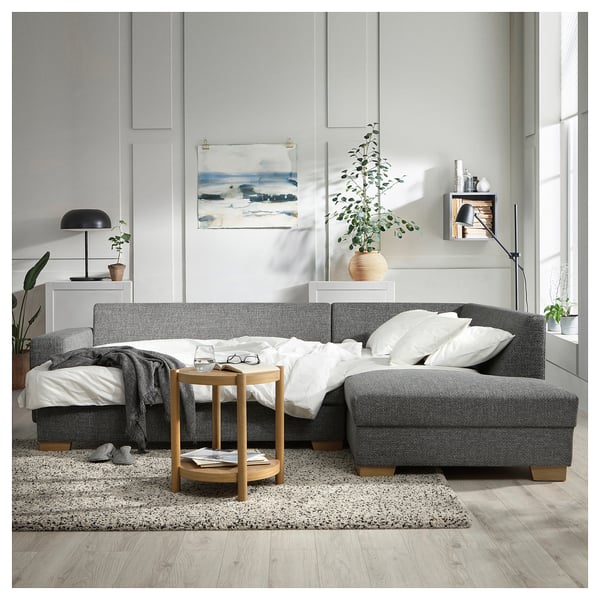 Moderne woonkamer: SÖRVALLEN grijze slaapbank met bijzettafel, kunst en planten.