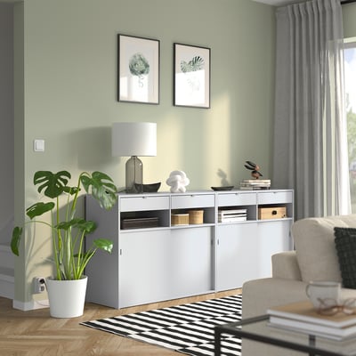Gezellige kamer wit SPIKSMED dressoir, moderne plant en stijlvolle inrichting.