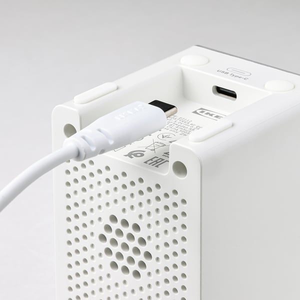Een witte luchtreiniger met een usb-c-poort, aangesloten op een witte stroomkabel.