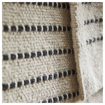 Rechthoekig beige en zwart gestreept vloerkleed.