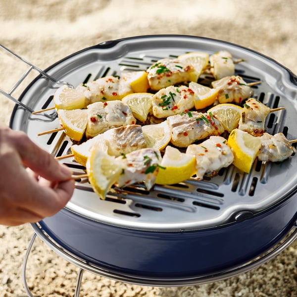 Citroenachtige visspiesjes grillen op STRANDÖNs draagbare, goed geventileerde houtskoolgrill met tang.