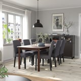 Moderne eetkamer met STRANDTORP tafel & stoelen. Lichte houten vloer. Grijze stoelen, zwarte hanglamp. Groot raam, grijze muren.