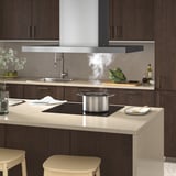 Moderne keuken met afzuigkap, led-verlichting en damppotten. Beige toonbanken, houten kasten en krukken.