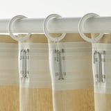 Drie witte gordijnringen met haken bevestigd aan een beige gordijn.