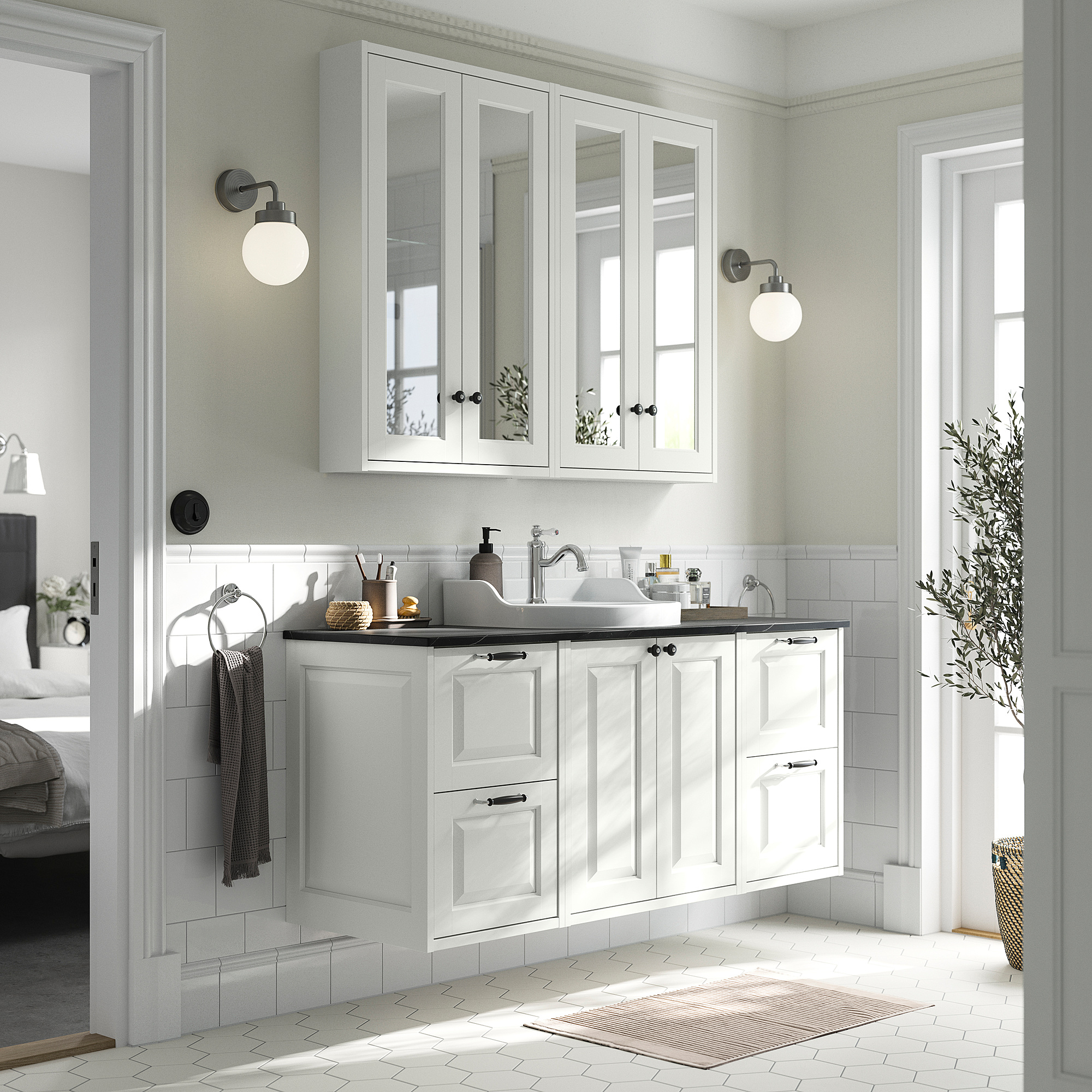 Witte TÄNNFORSEN badmeubel met klassiek design, keramische wastafel, wandspiegels, verlichting, handdoekenrek, plant.