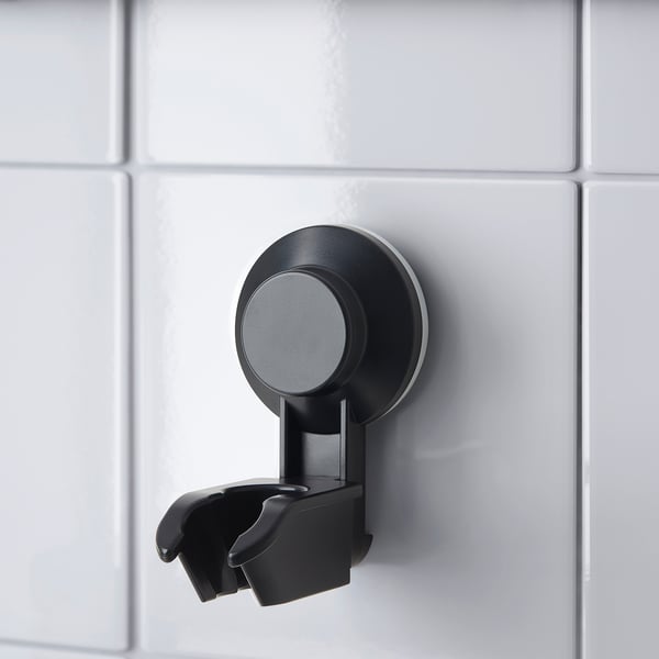 Zwarte zuignap douchebeugel op betegelde wand. Houdt handdouche netjes vast.