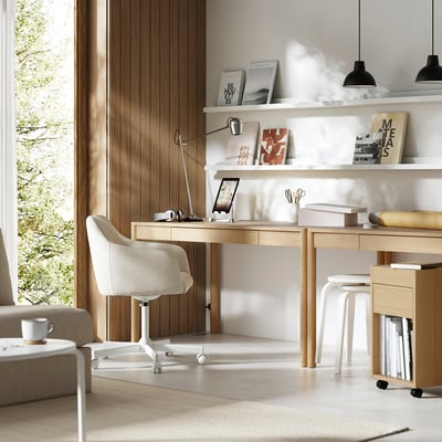 Modern thuiskantoor met licht houten bureau, witte stoel en planken. Eikenfineer, strak design en stijlvolle accessoires.