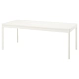 Een witte TONSTAD eettafel met een rechthoekige vorm en strak design, voorzien van een melamine blad en stevige houten poten.