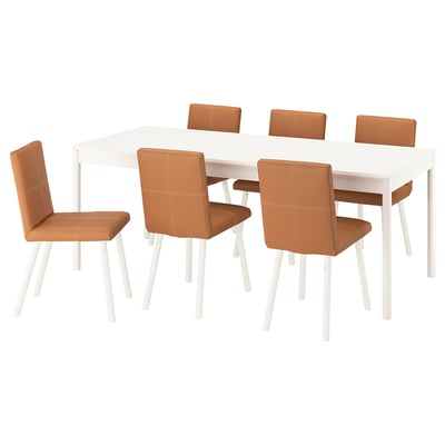 Eethoek met witte tafel, zes bruine gestoffeerde stoelen. Modern design, zachte randen, stevige poten.