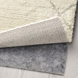 Tapijt in berberstijl in neutrale toon met dikke, zachte pool. Getoond met antislip onderlaag van het tapijt, wat het comfort en de veiligheid verbetert.