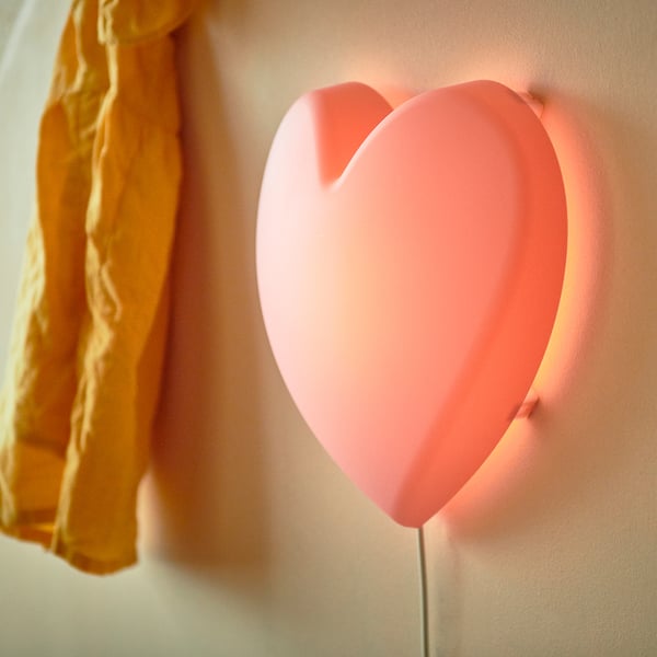 Hartvormige roze wandlamp voor kinderen. Gemaakt van gerecycled plastic, straalt zacht licht uit.