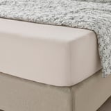 VÅRVIAL hoeslaken in lichtbeige op netjes opgemaakt bed, bedekt met gebloemd dekbed voor een gezellige nachtrust.