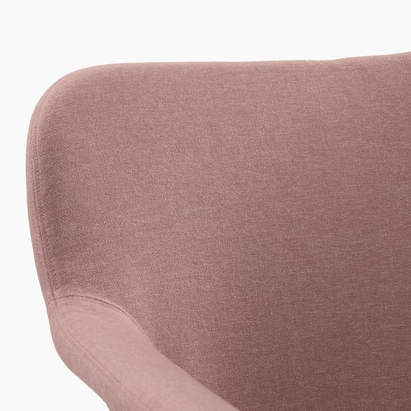 Een close-up van een zachte, getextureerde roze-bruine stoffen fauteuil, met zijn pluche, uitnodigende bekleding.