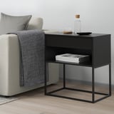 Zwarte bijzettafel met 2 planken, naast de bank, houdt tijdschriften, minimalistisch.