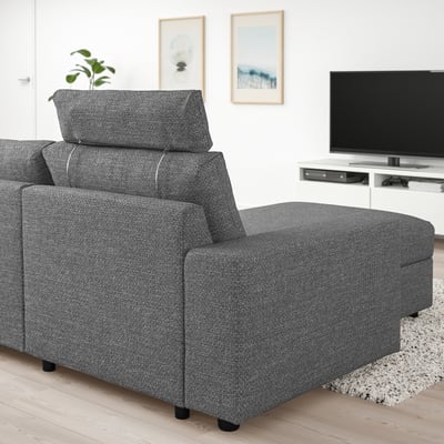 Grijze VIMLE sectionele bank met verlengde zitting, bij een grote tv op standaard, in een gezellige woonkamer.