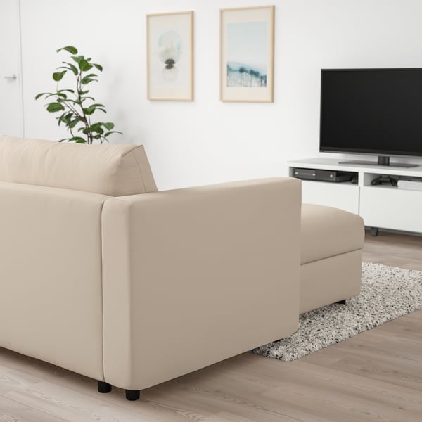 Moderne woonkamer: grote beige VIMLE bank, grijs vloerkleed, plant, tv, minimalistische kunst aan de muur.