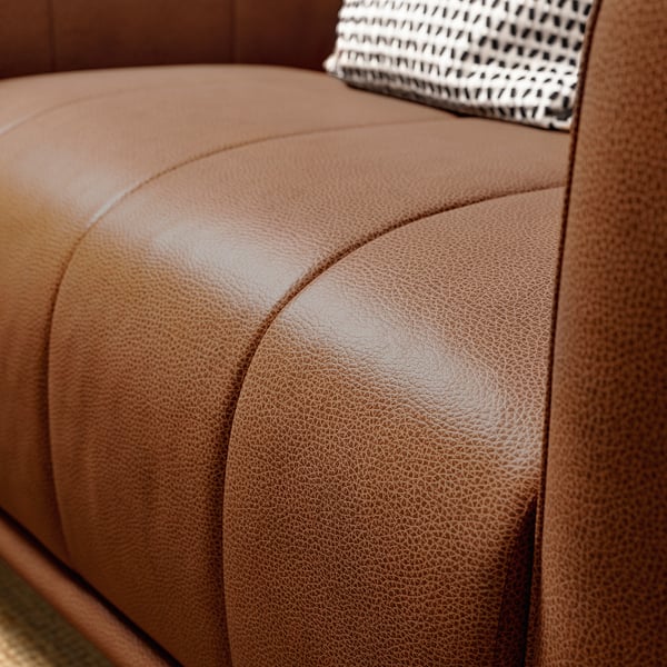 Bruine leren fauteuil met gladde, afgeronde hoeken en een comfortabele, uitnodigende vorm.