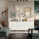 Minimalist living room with BESTÅ sideboard, art, turquoise sofa, black chair.