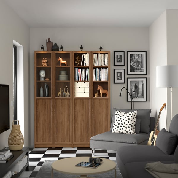 Living room with tall BILLY bookcase, grey sofa, guitar, black/white floor.