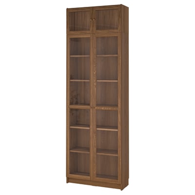 A tall wooden BILLY bookcase with glass doors, dark brown, rectangular, and modern design.