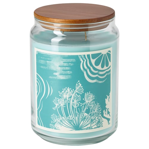 Aqua blue glass candle jar with wooden lid, floral white label, cylindrical, for home fragrance.
